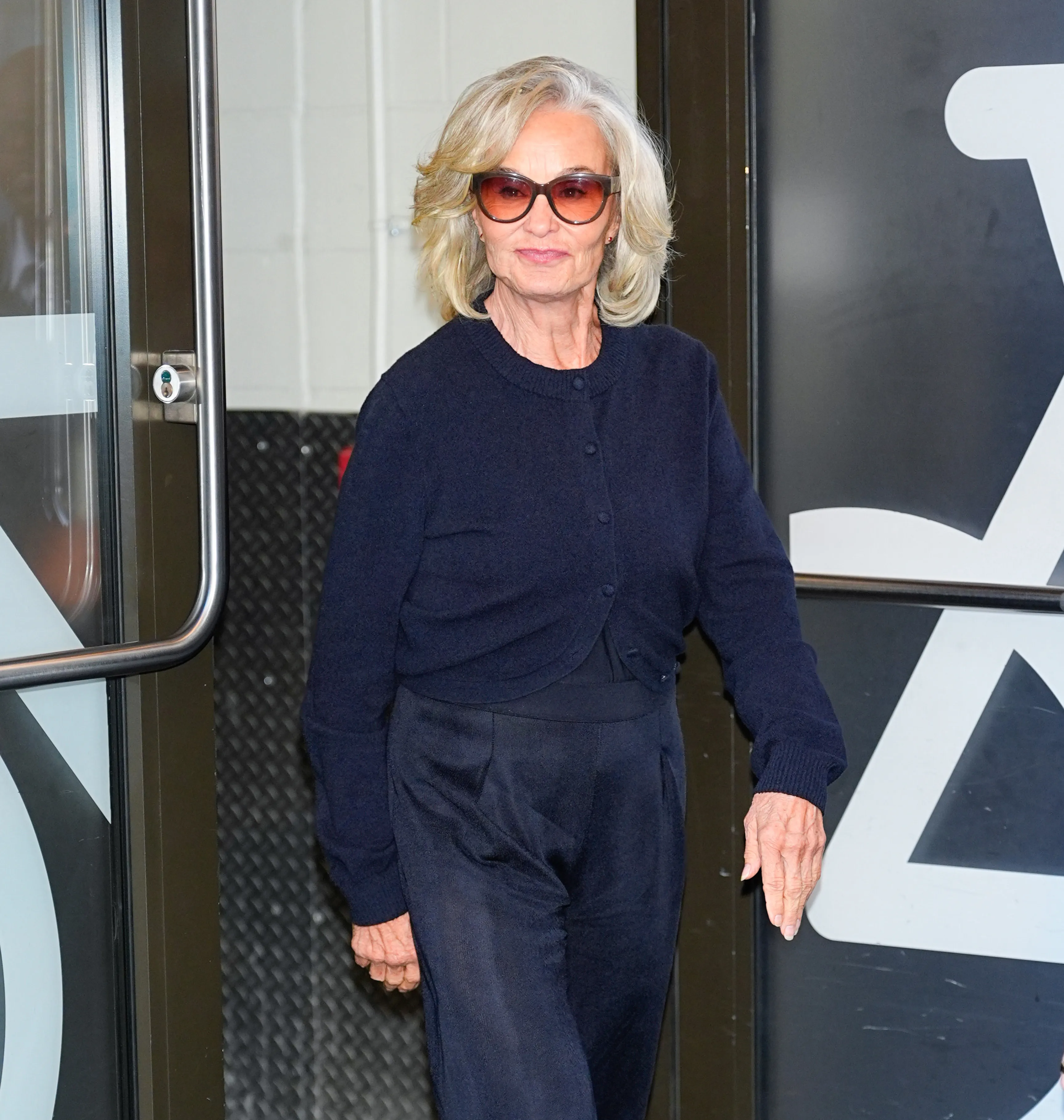 Jessica Lange wearing sunglasses and a navy blue outfit exiting ABC Studios in New York City.