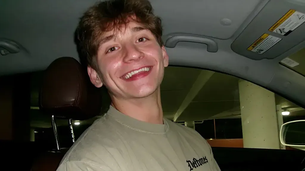 Jimmy Dorner sitting in the passenger seat of a car and smiling.