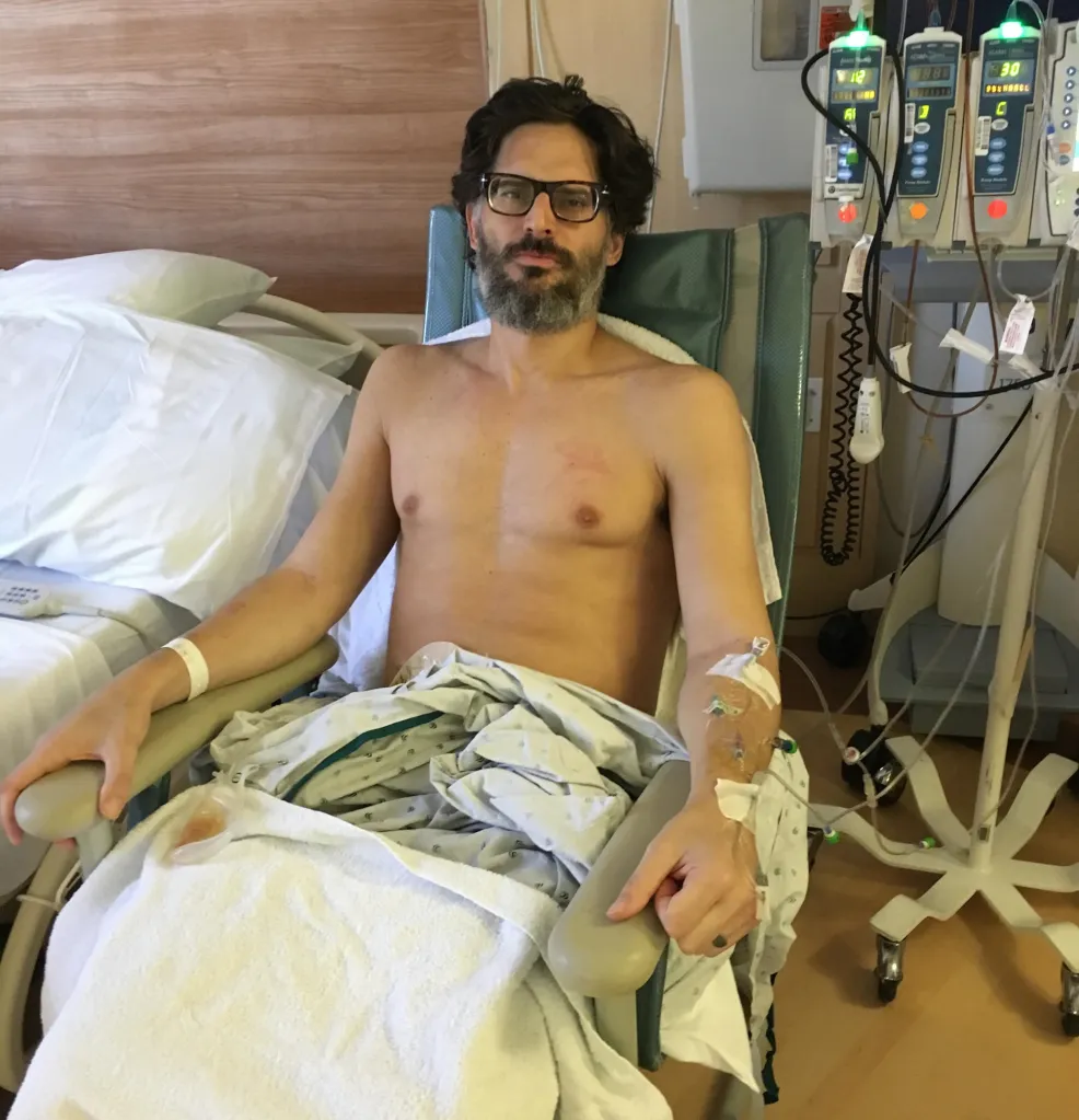 Joe Manganiello seated in a hospital chair with IV lines in his arms.