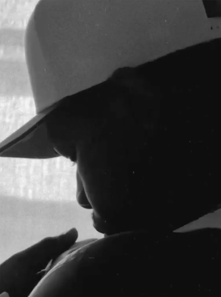 John Boyega holding a baby in a black and white close-up shot.