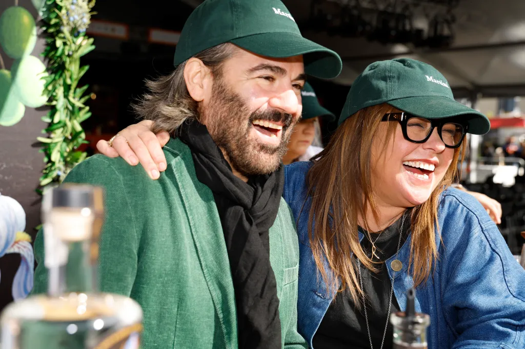 John Cusimano and Rachael Ray laugh together while visiting a gin booth.