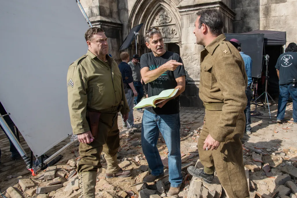 John Goodman, director George Clooney, and Jean Dujardin on the set of The Monuments Men.