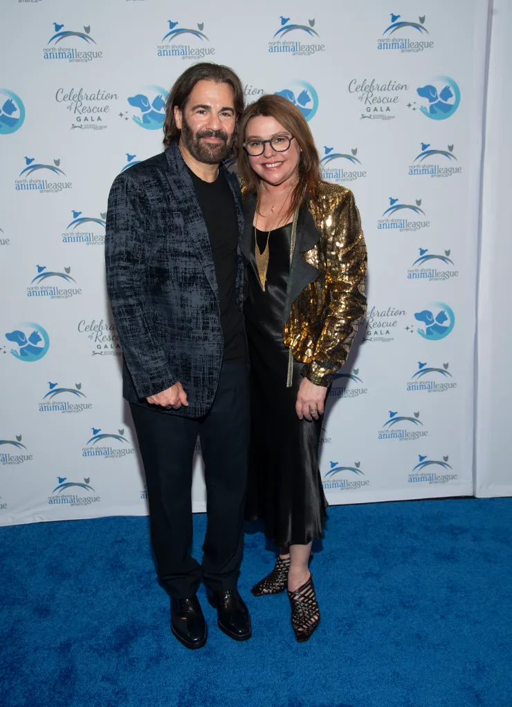 John M. Cusimano and Rachael Ray pose on a blue carpet in front of a step-and-repeat backdrop.