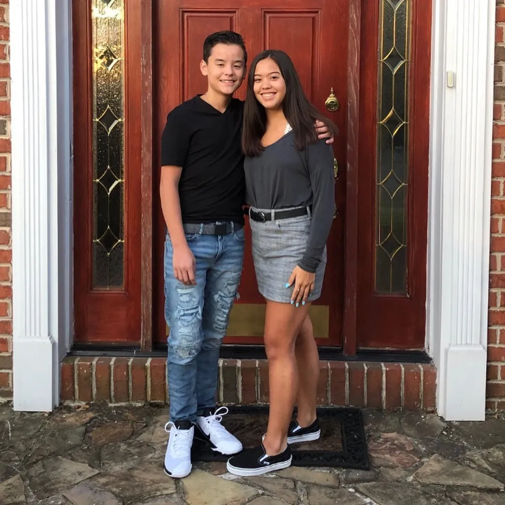 Collin and Hannah Gosselin standing in front of a red wooden door.