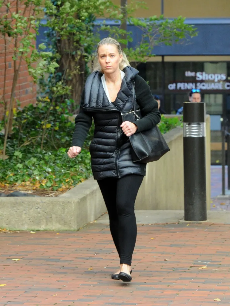 Kate Gosselin walking while looking down, wearing a black puffer jacket and carrying a black handbag.