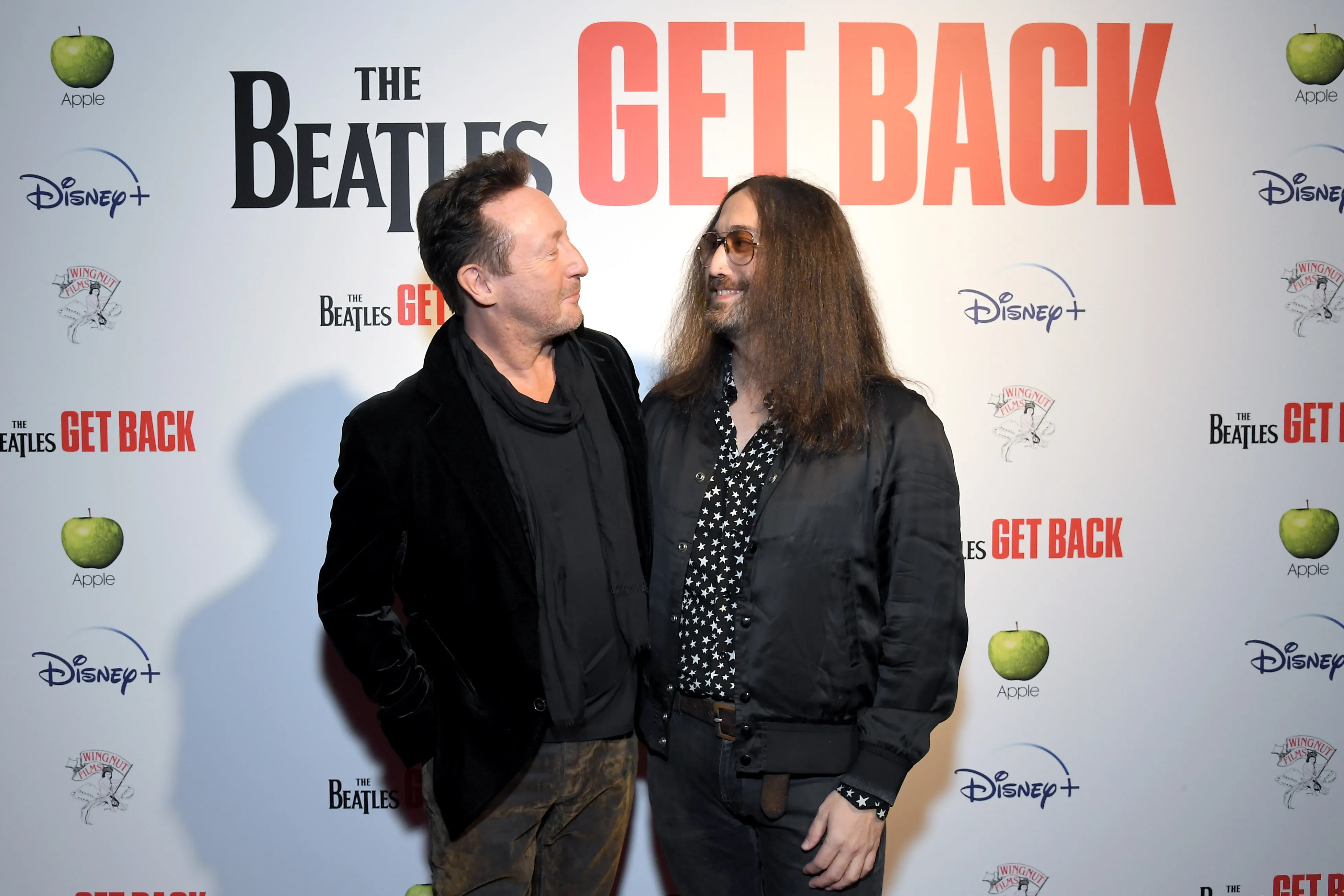 Julian Lennon and Sean Lennon stand together in front of a 