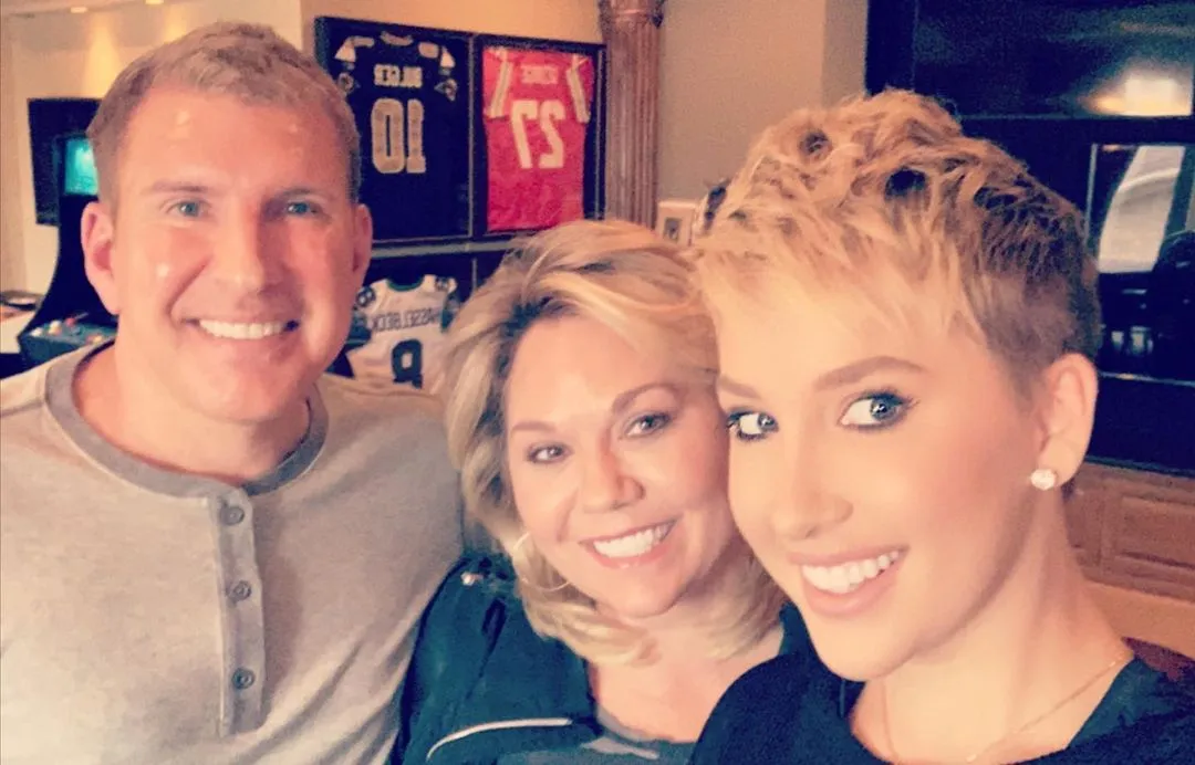 Todd Chrisley, Julie Chrisley, and Savannah Chrisley smiling together.