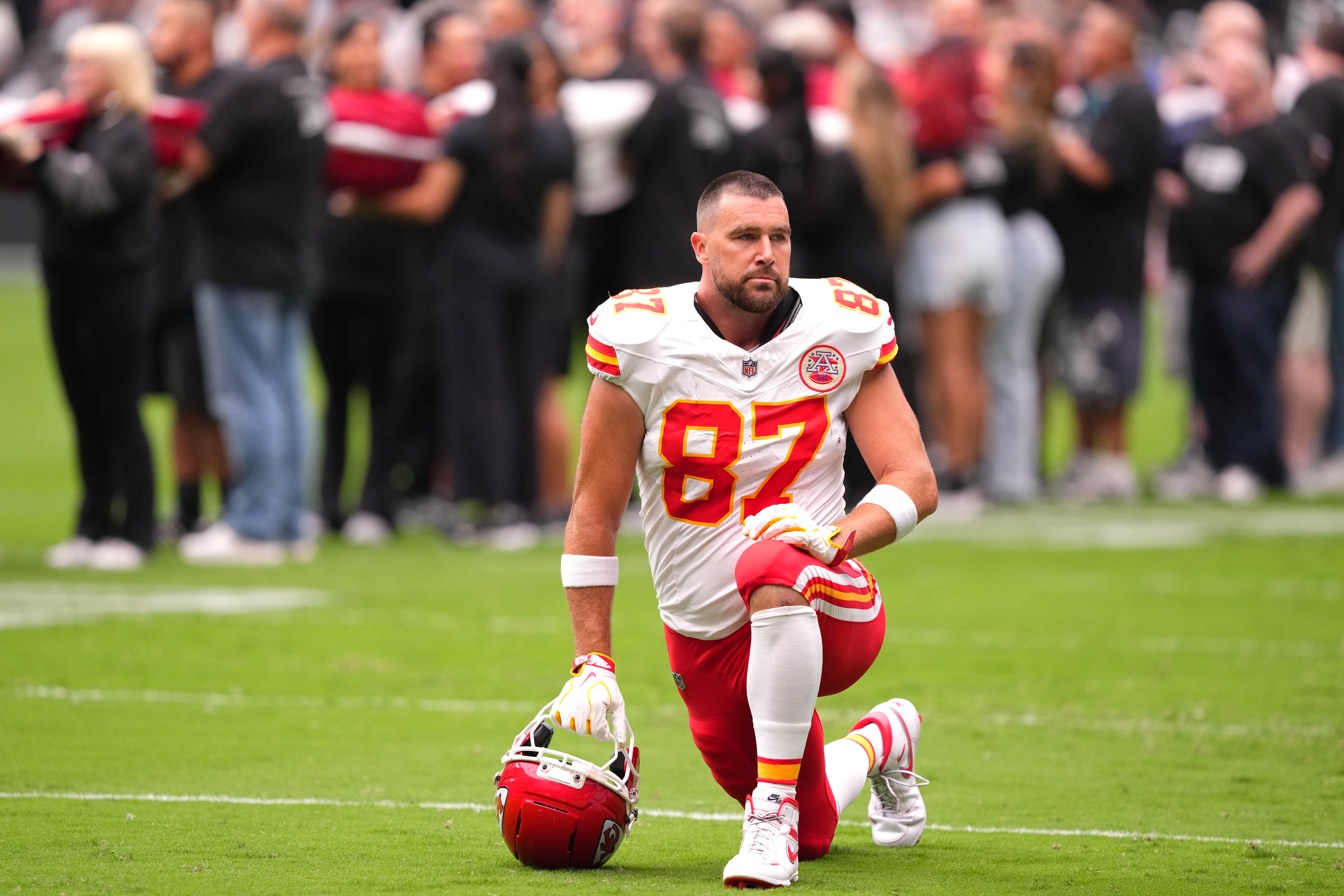 Kansas City Chiefs tight end Travis Kelce kneels on the field during warmups.