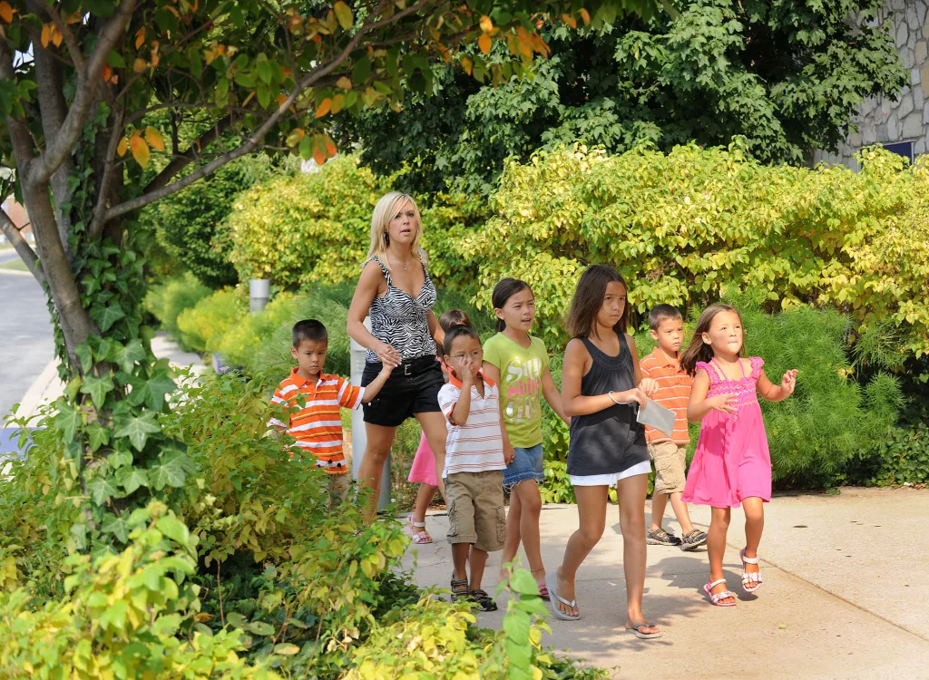 Kate Gosselin and her children walk on a sidewalk near a store.