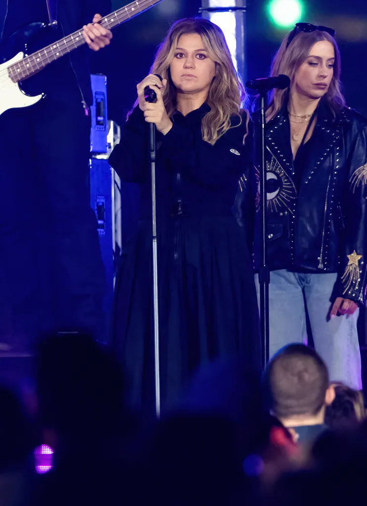 Kelly Clarkson performing on stage with her band.