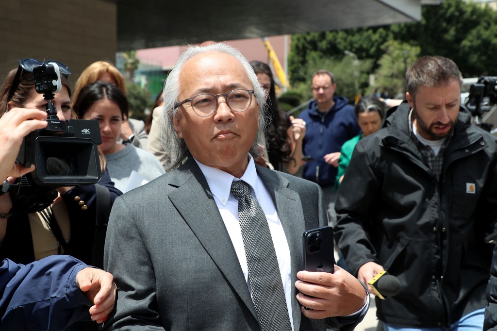 Kenneth Iwamasa exits the Los Angeles Federal Court surrounded by media.