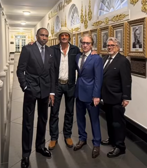 Stephen A. Smith, Kid Rock, Bill Maher, and Donald Trump pose for a photo together in a hallway.