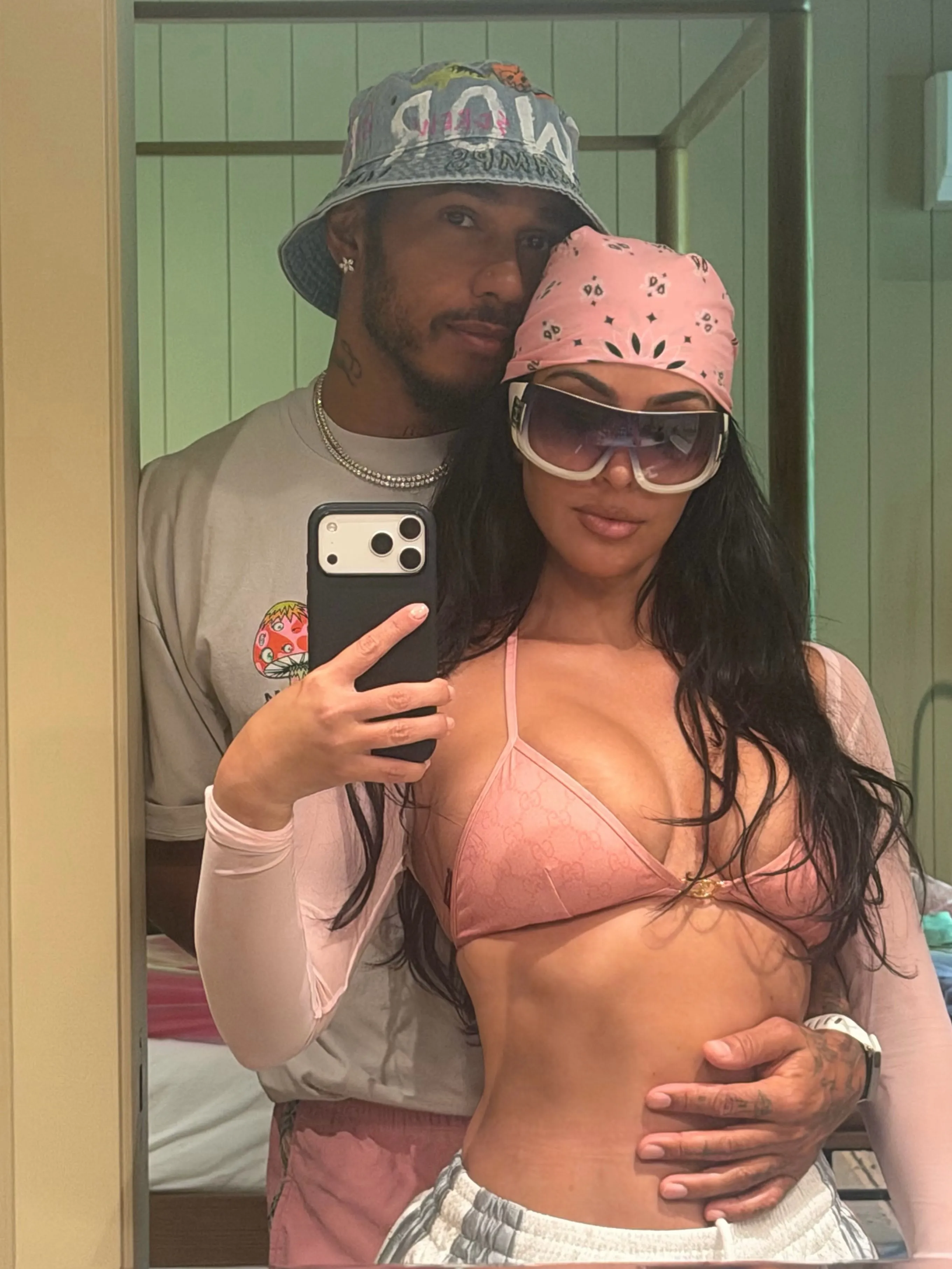 Kim Kardashian and Lewis Hamilton taking a mirror selfie together.