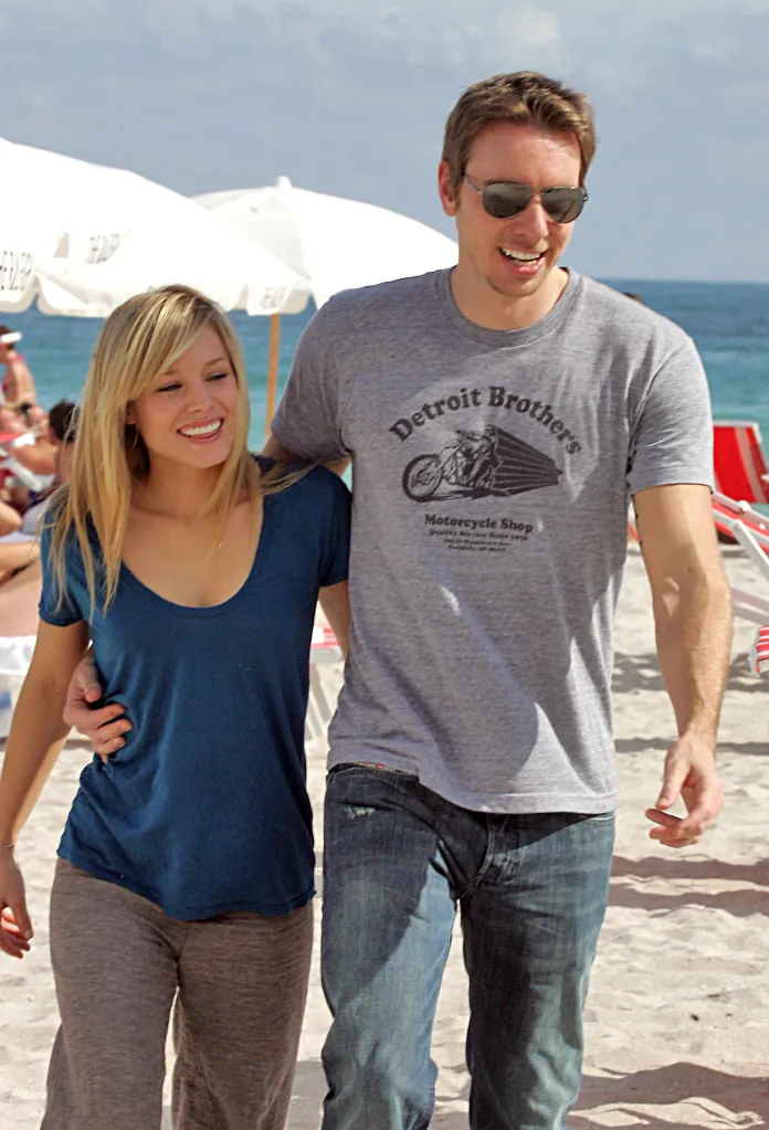 Kristen Bell and Dax Shepard walking arm in arm on a beach.