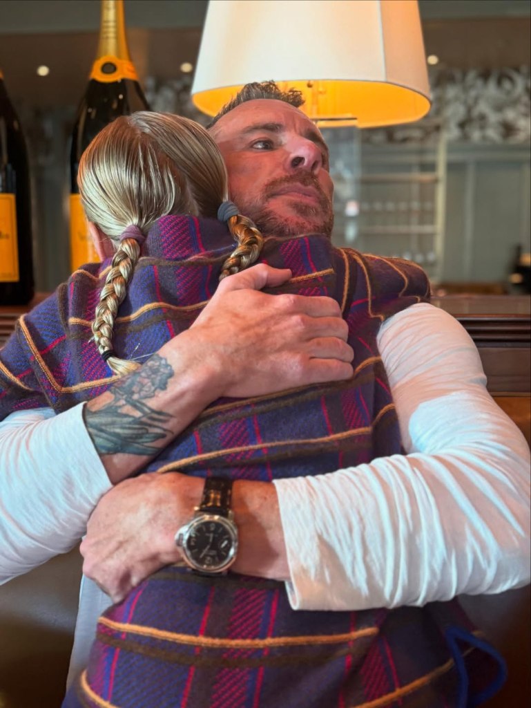 Dax Shepard hugging someone with braided hair.