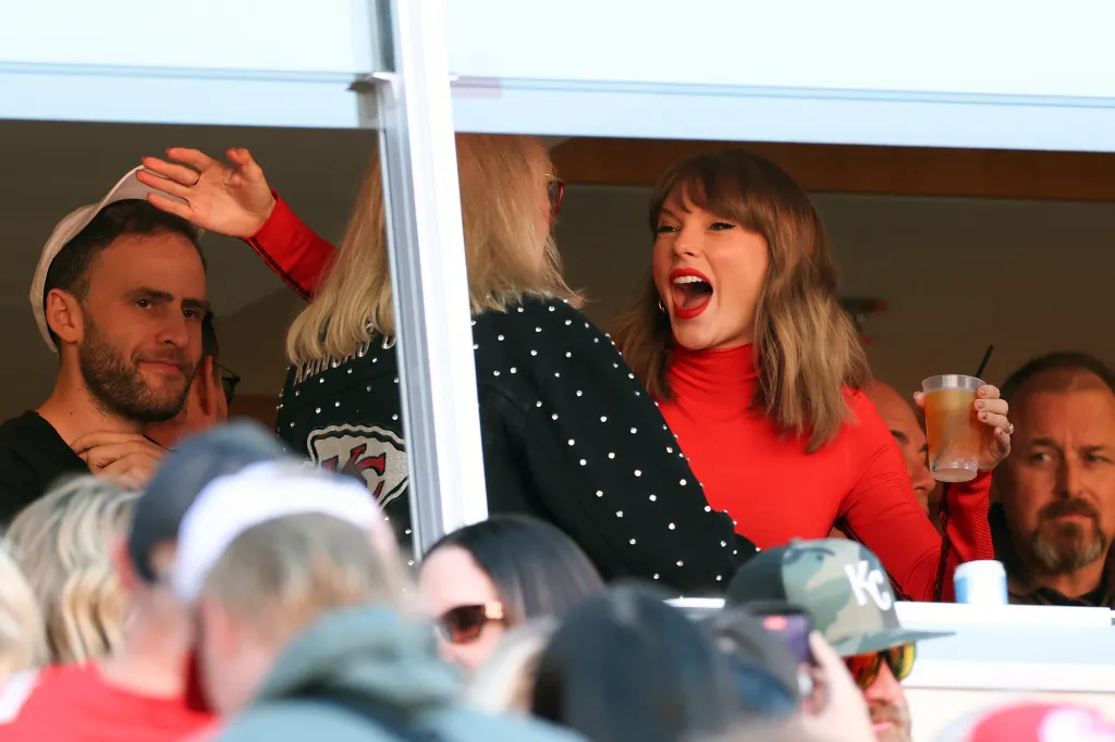 Donna Kelce hugs Taylor Swift in a stadium suite during a football game.