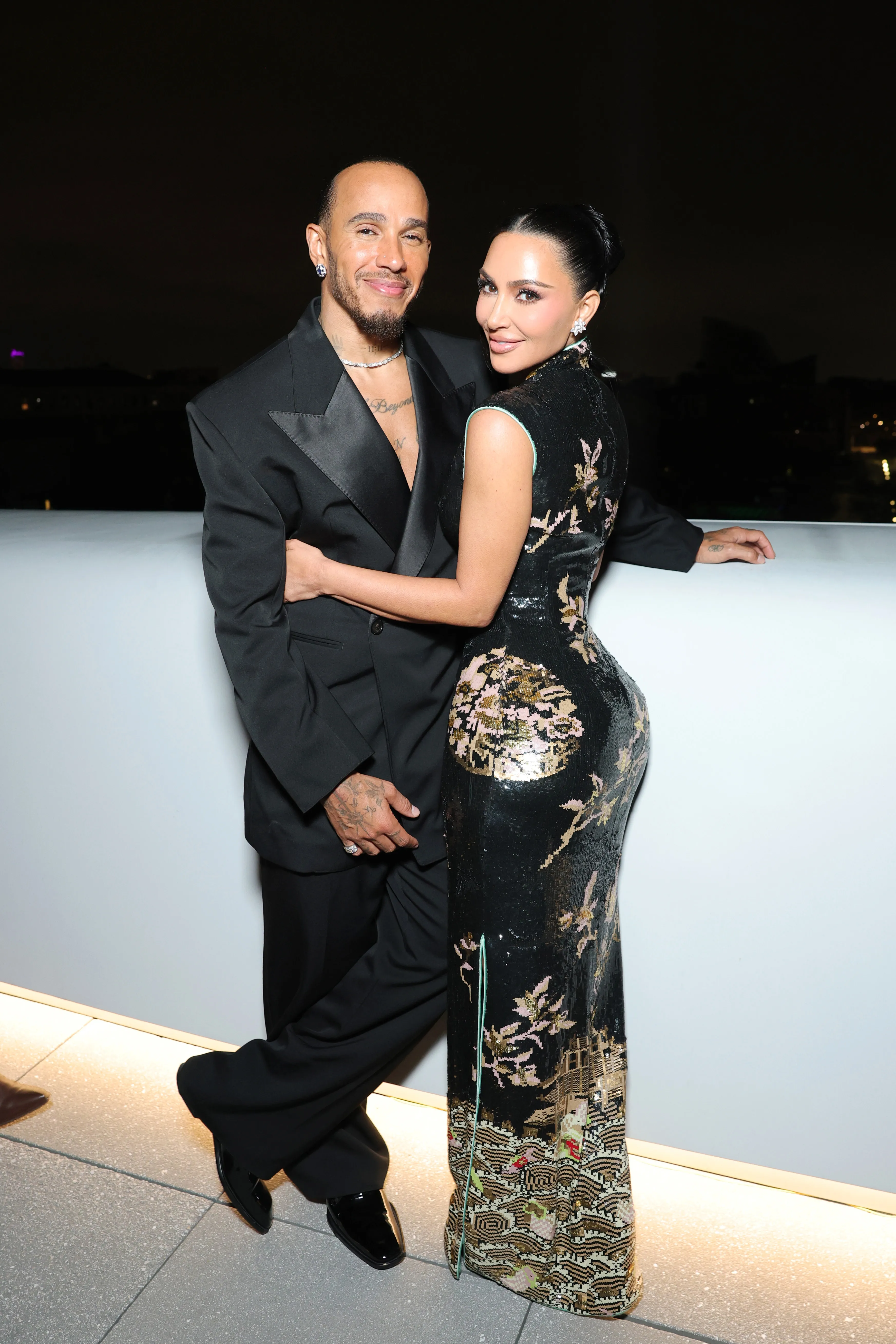 Lewis Hamilton and Kim Kardashian posing together at an event.