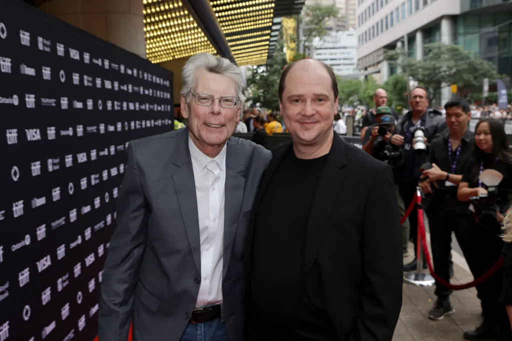 Stephen King and Mike Flanagan pose together on the red carpet at a film premiere.