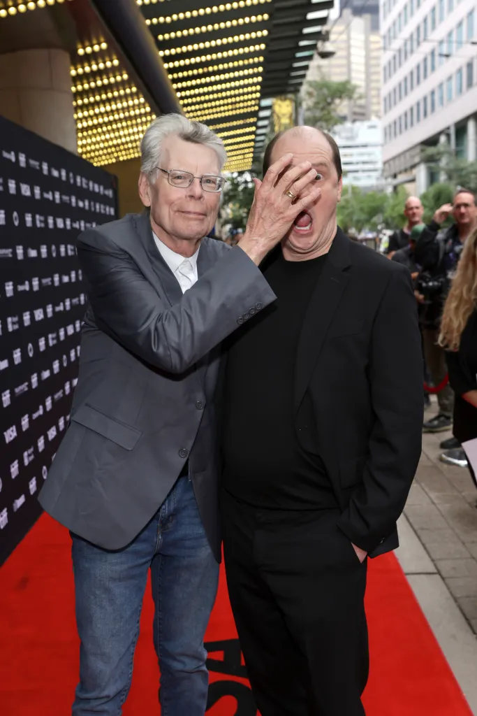 Stephen King jokingly covering Mike Flanagan's face on the red carpet.