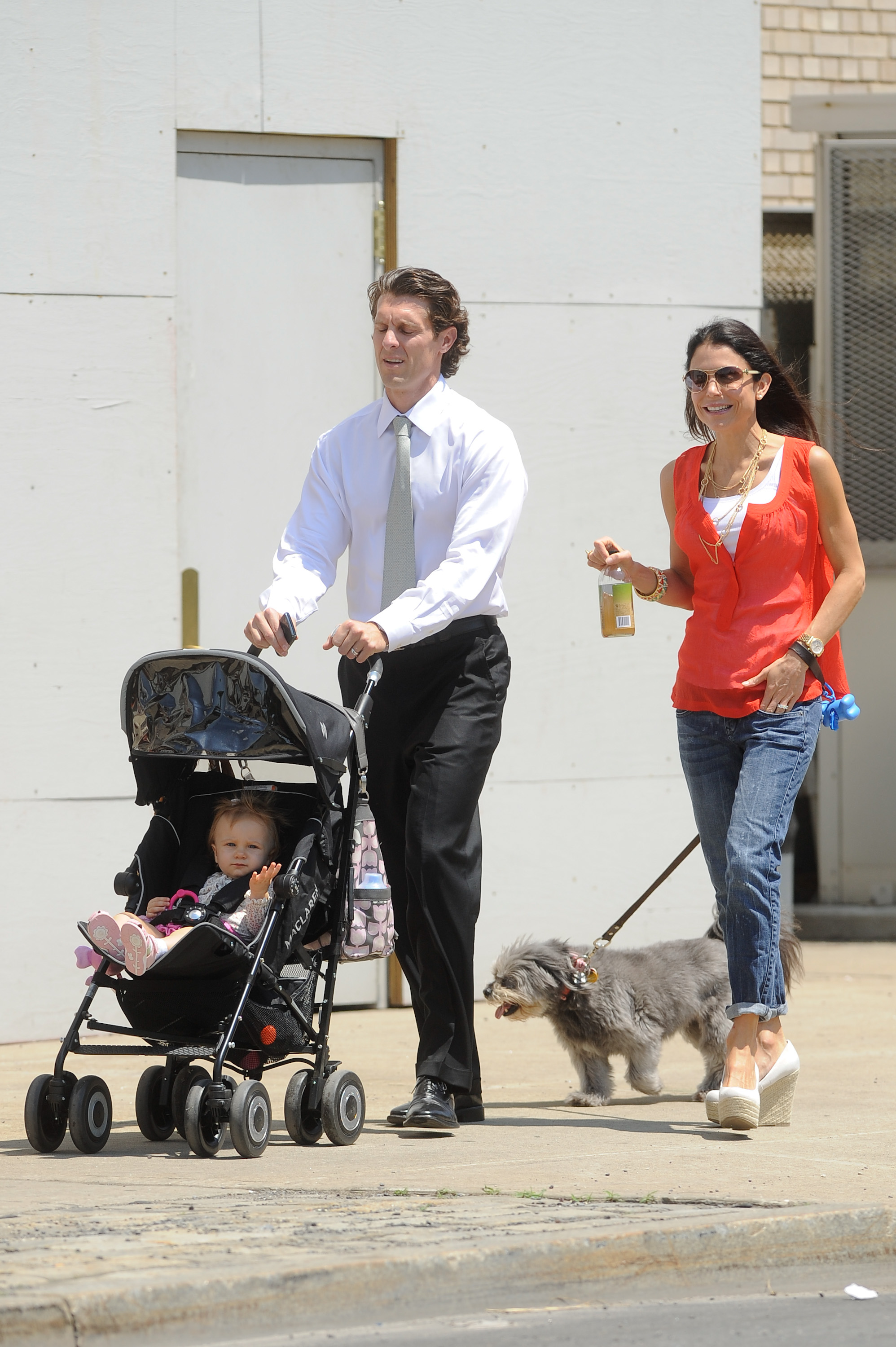 TV personalities Bryn Hoppy, Jason Hoppy, and Bethenny Frankel walk together, with Jason pushing a stroller and Bethenny walking a dog.