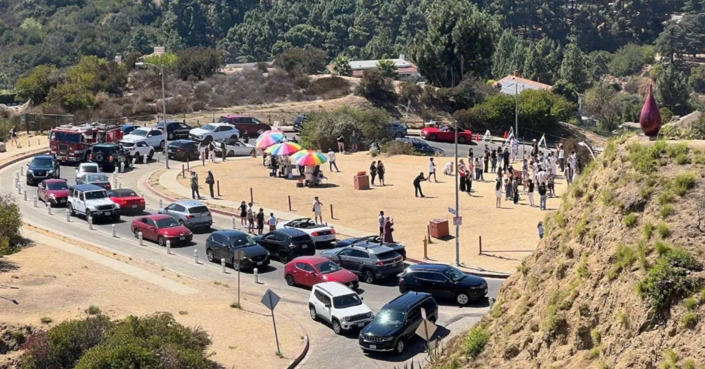 Crowded streets and visitors gathered in a residential area near the Hollywood sign.