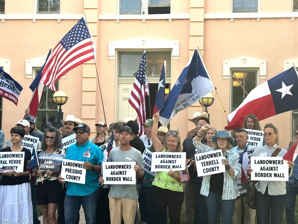 Landowners and other supporters hold signs against the construction of a border wall in Texas.