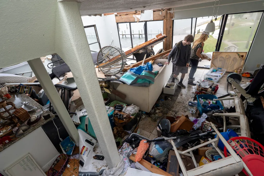 Laura and Alex Dean clean out their home severely damaged by Hurricane Isaias.