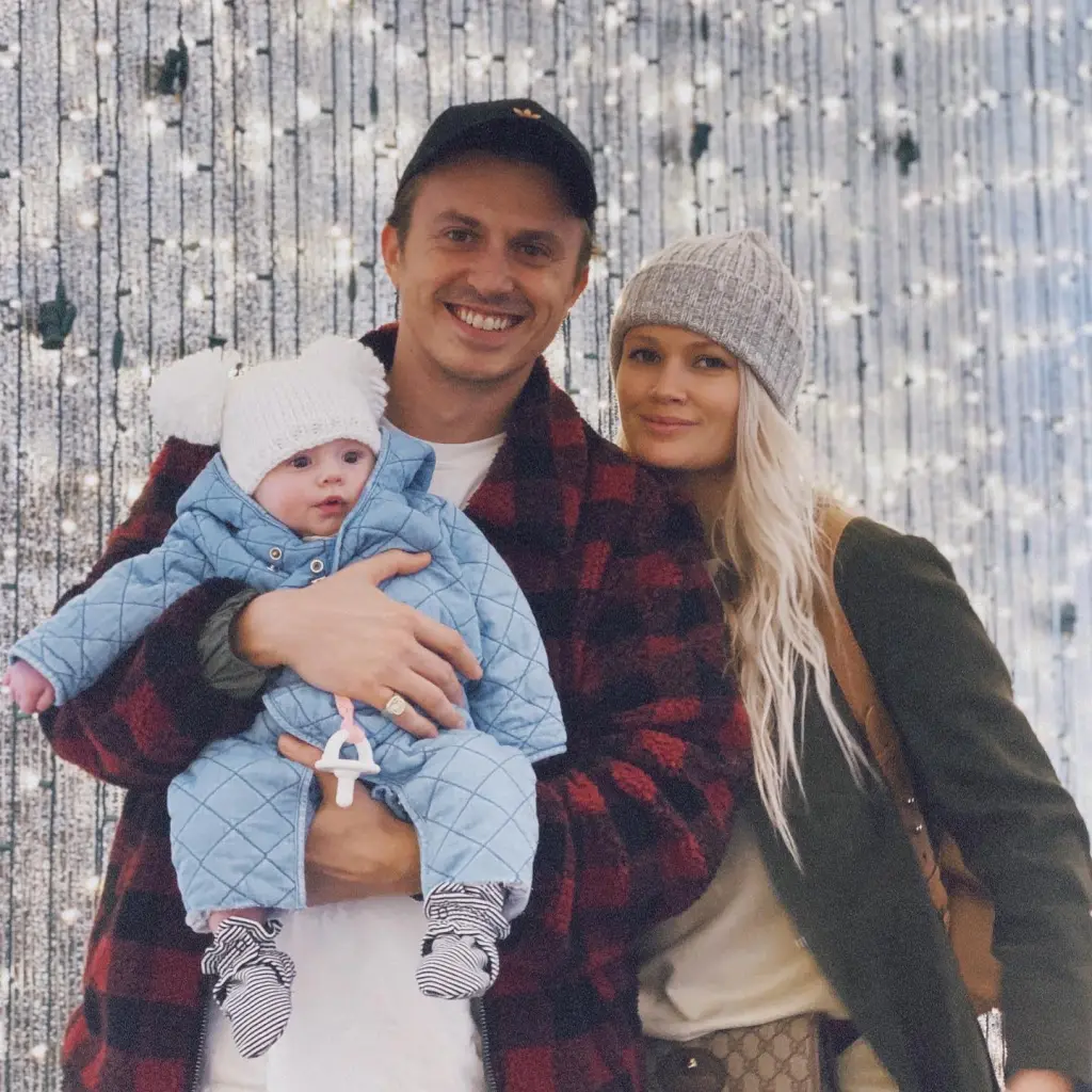 Lauren Bennett with her family in front of a backdrop of lights.