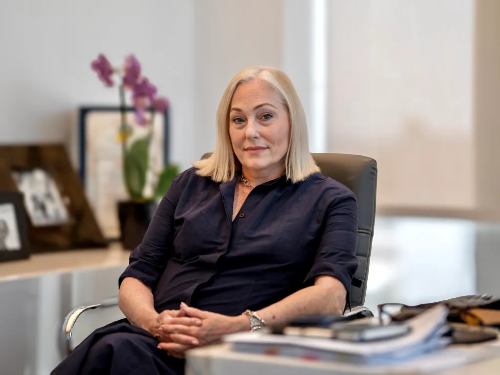 Lawyer Ellyn Garofolo, in black shirt and pants, seated in an office, with her hands clasped.
