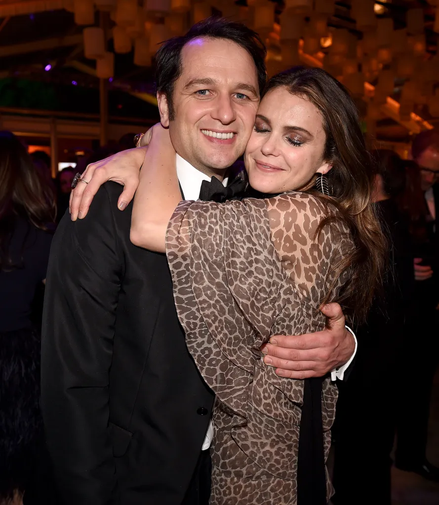 Matthew Rhys and Keri Russell embrace at a party.