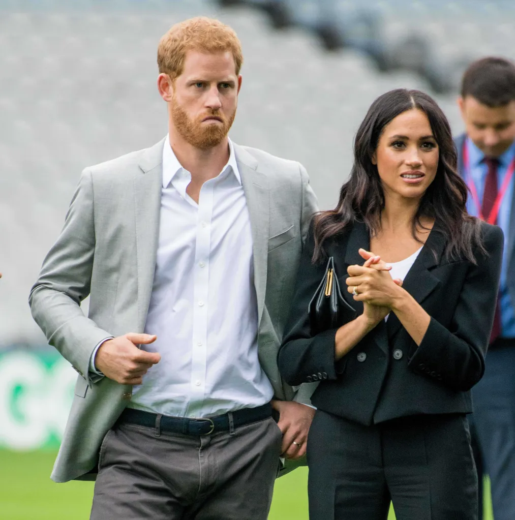 Prince Harry and Meghan Markle standing together outdoors.