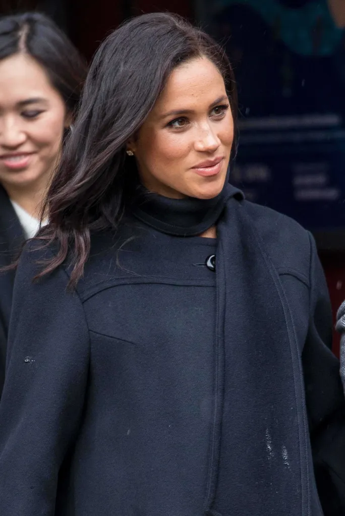Meghan Markle wearing a dark coat during an outing.