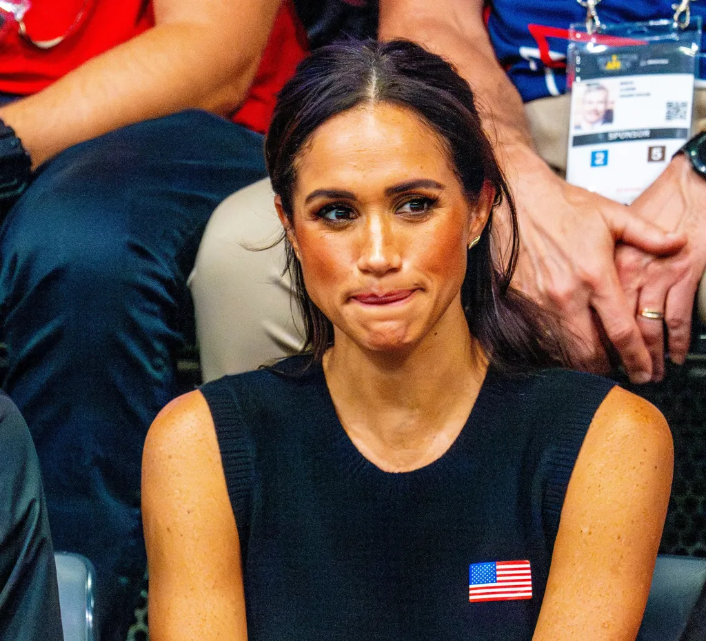 Meghan Markle wearing a black top with an American flag pin.