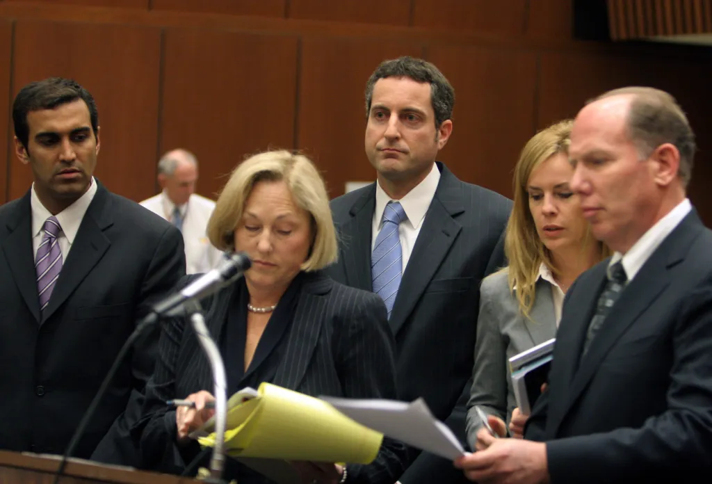 Howard K. Stern, in a dark suit and blue tie, and Dr. Sandeep Kapoor, in a black suit and purple tie, during court proceedings with their lawyers, Steven H. Sadow and Ellyn S. Garofalo, in black suits.