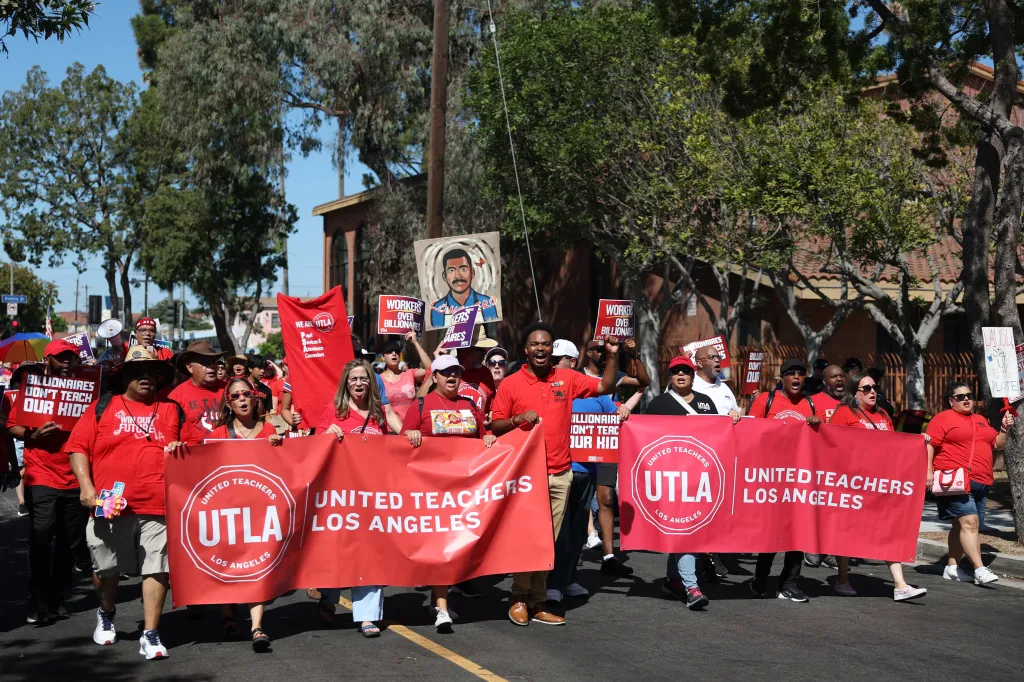 People march in support of United Teachers Los Angeles (UTLA) carrying banners and signs during a labor rally.