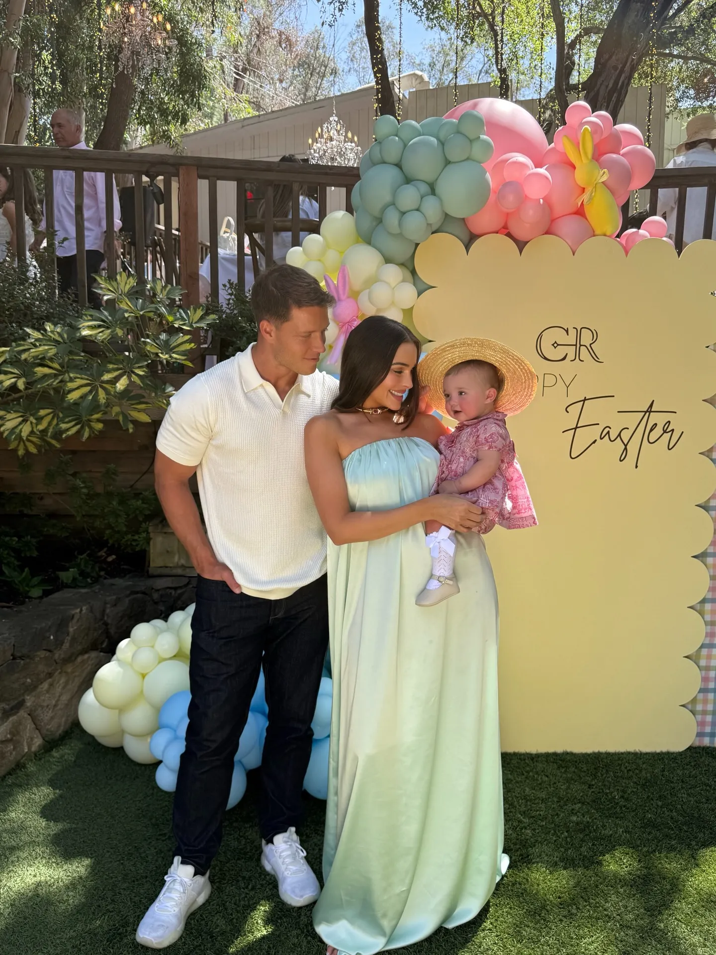 Olivia Culpo with her partner and baby Colette in front of an Easter background.