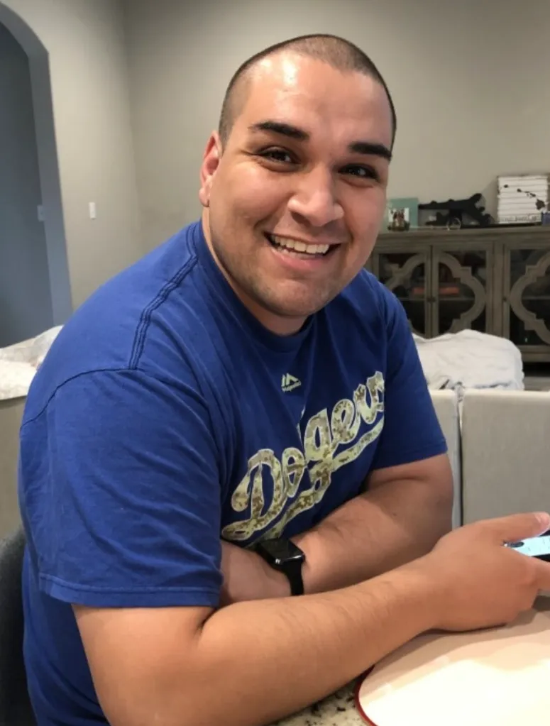 Lt. Col. Gabriel Estrella smiling while wearing a blue Dodgers shirt.