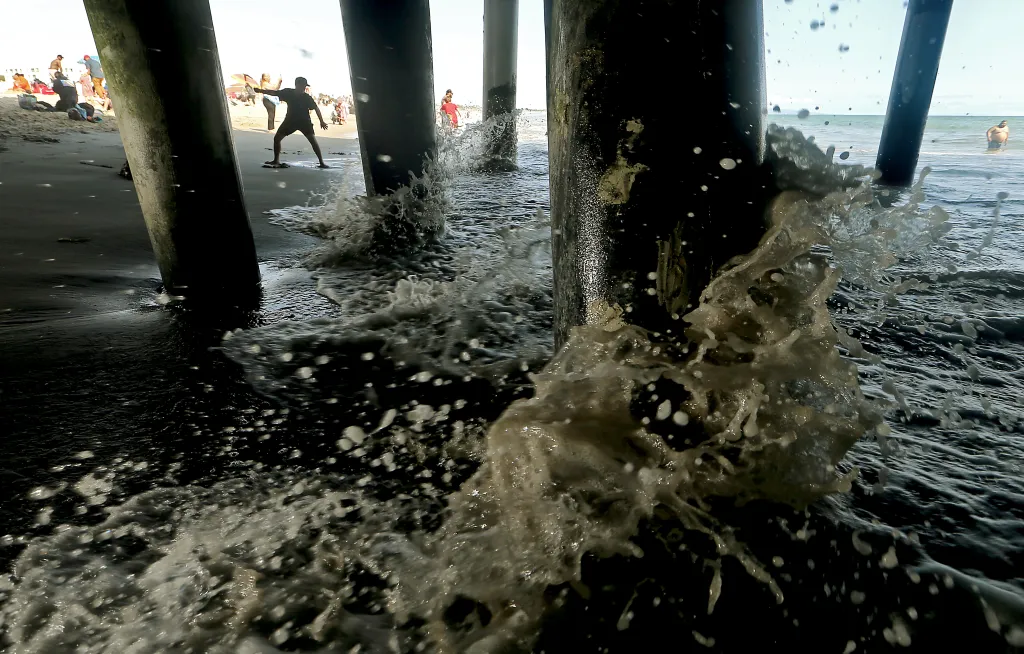 Waves wash ashore among the pillars of the Santa Monica Pier.