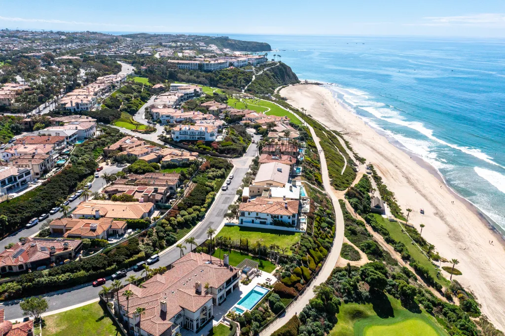 Aerial view of luxurious coastal homes and a sandy beach in Dana Point, California.