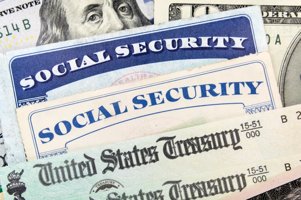 Macro view of Social Security cards, United States Treasury checks and cash.