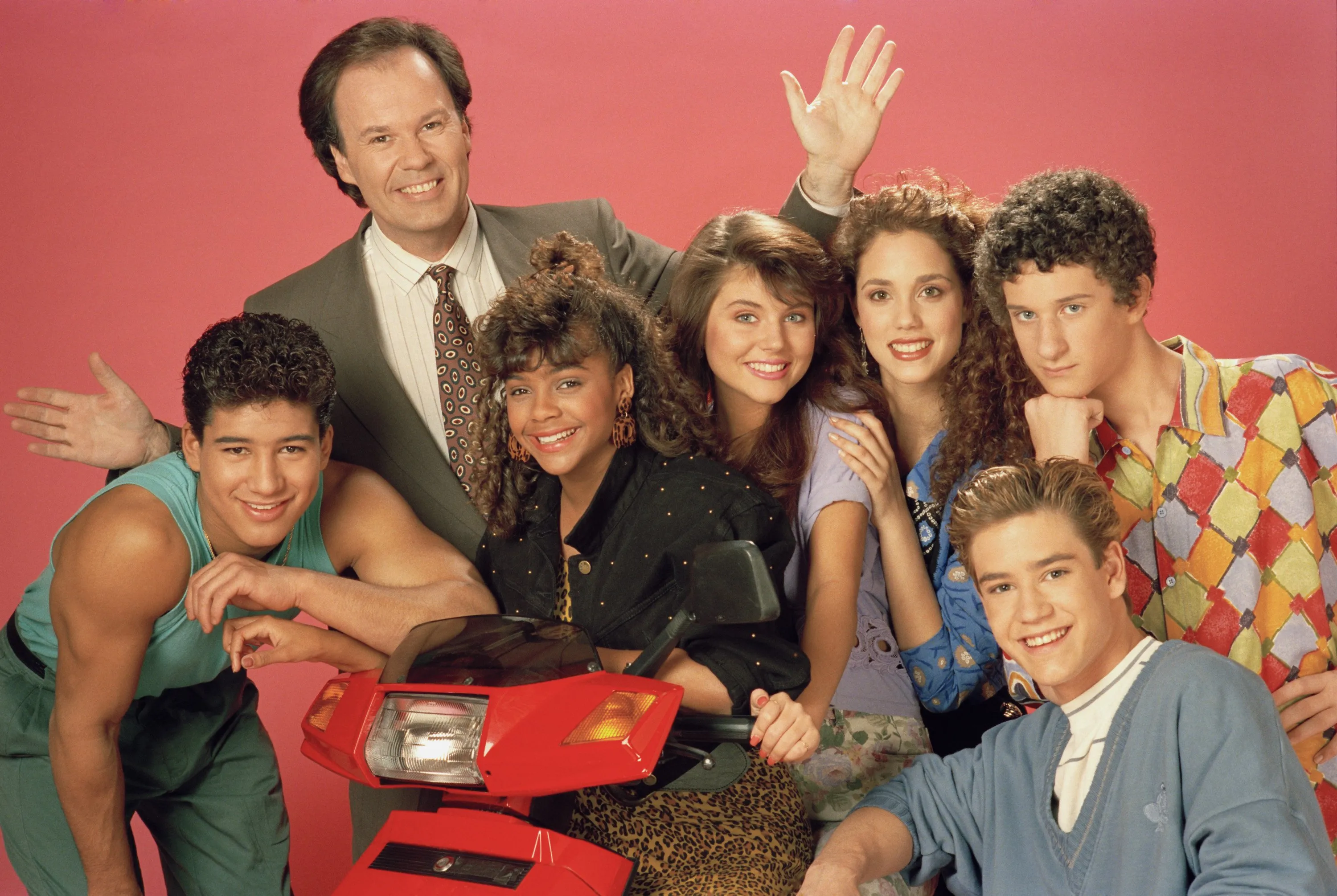 Cast photo of the TV show Saved by the Bell, featuring the main teenage characters and Principal Belding.