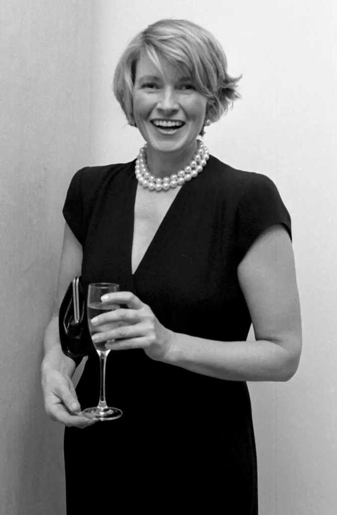 Martha Stewart smiling while holding a glass of champagne at the Lenox Hill Hospital Benefit Cocktail Party.