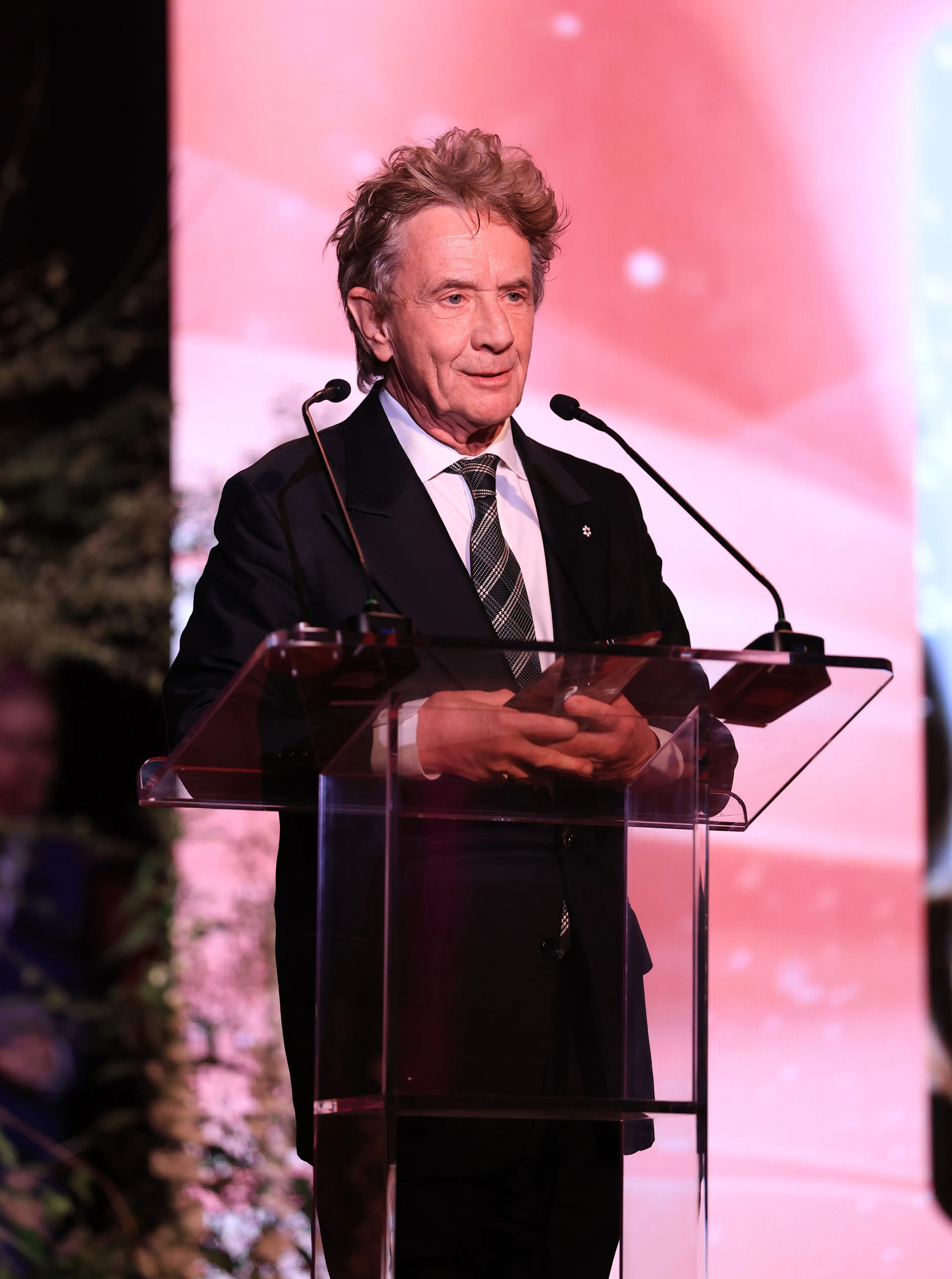 Martin Short speaks at a podium during the Fourth Annual Rare Impact Fund Benefit.
