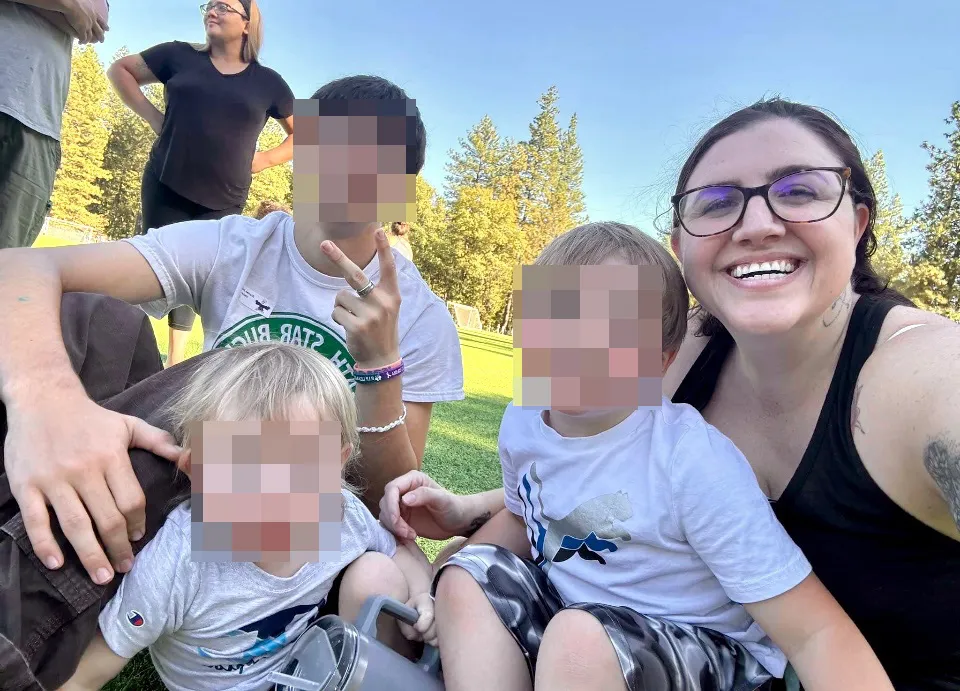 Martina poses with her three sons outdoors.