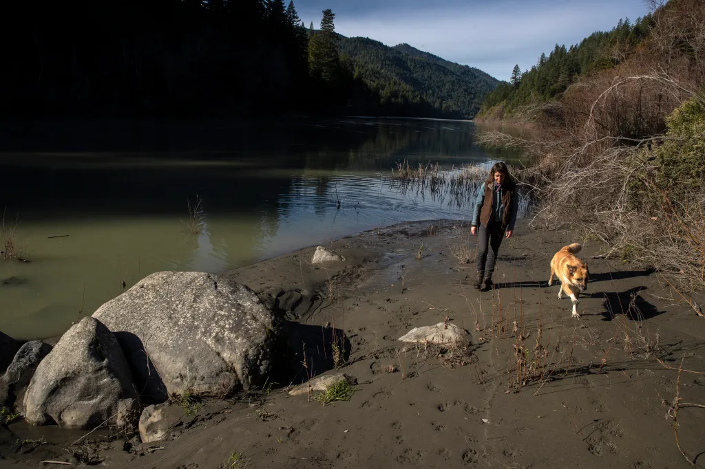 Mary Gaturud walks along the Eel River with her dog in Redcrest, California.