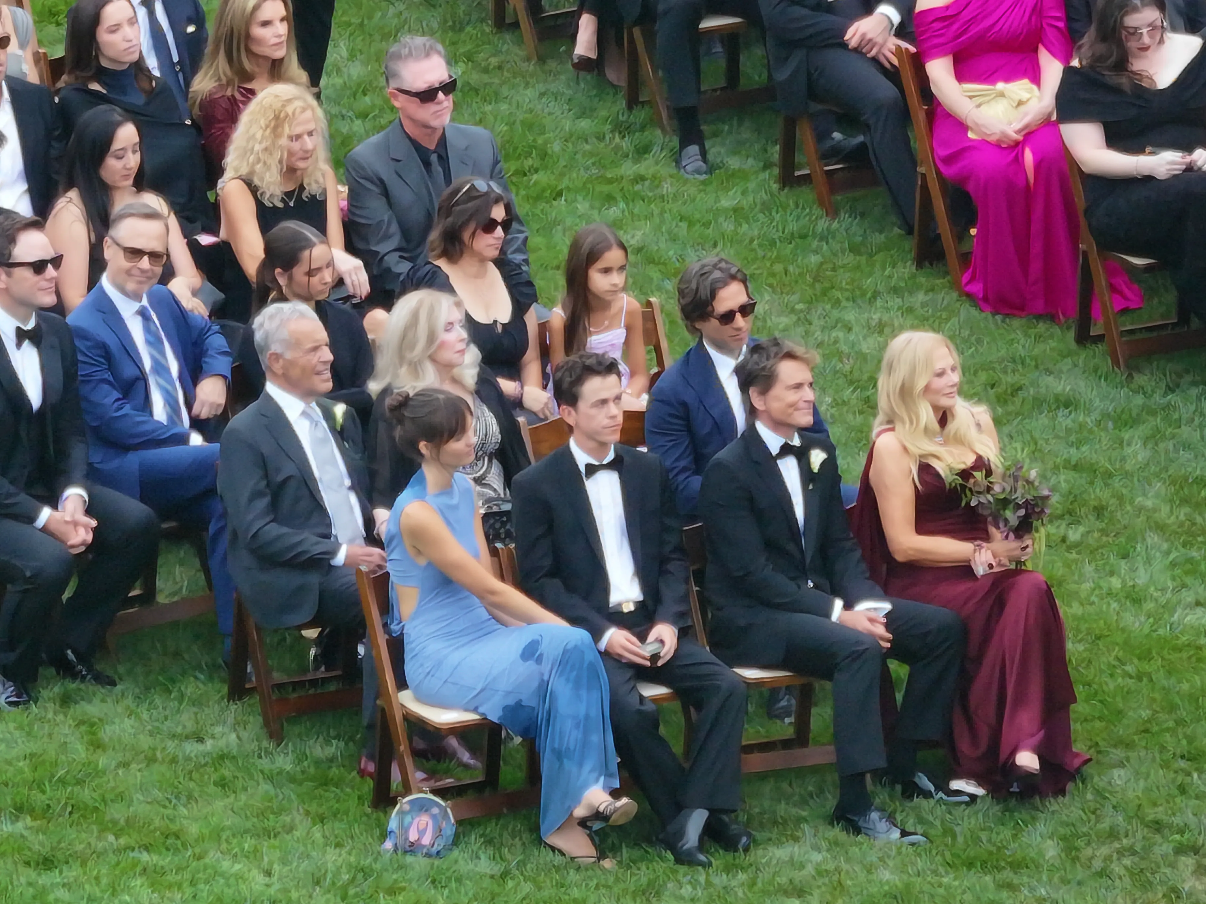 Guests seated on chairs in the grass at Matthew Lowe's wedding, including Rob Lowe and Maria Shriver.