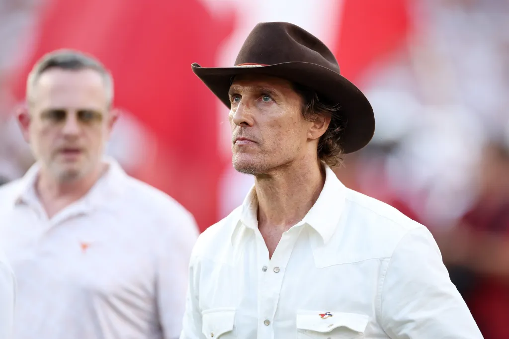 Matthew McConaughey wearing a cowboy hat at a football game.