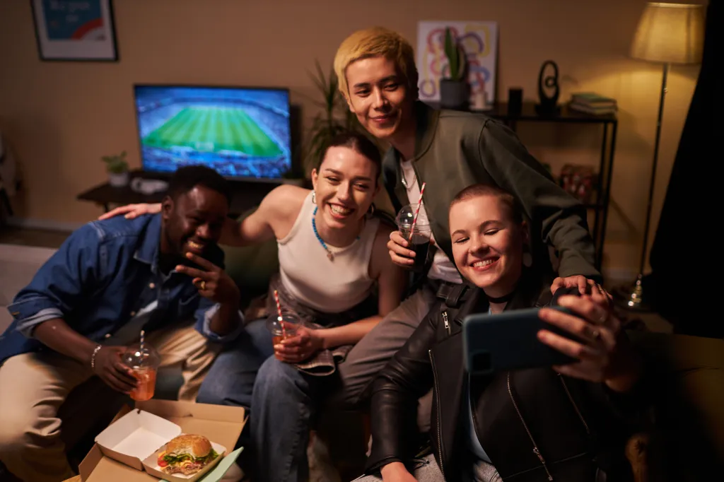 Photo of four multi-ethnic young adults posing for a selfie