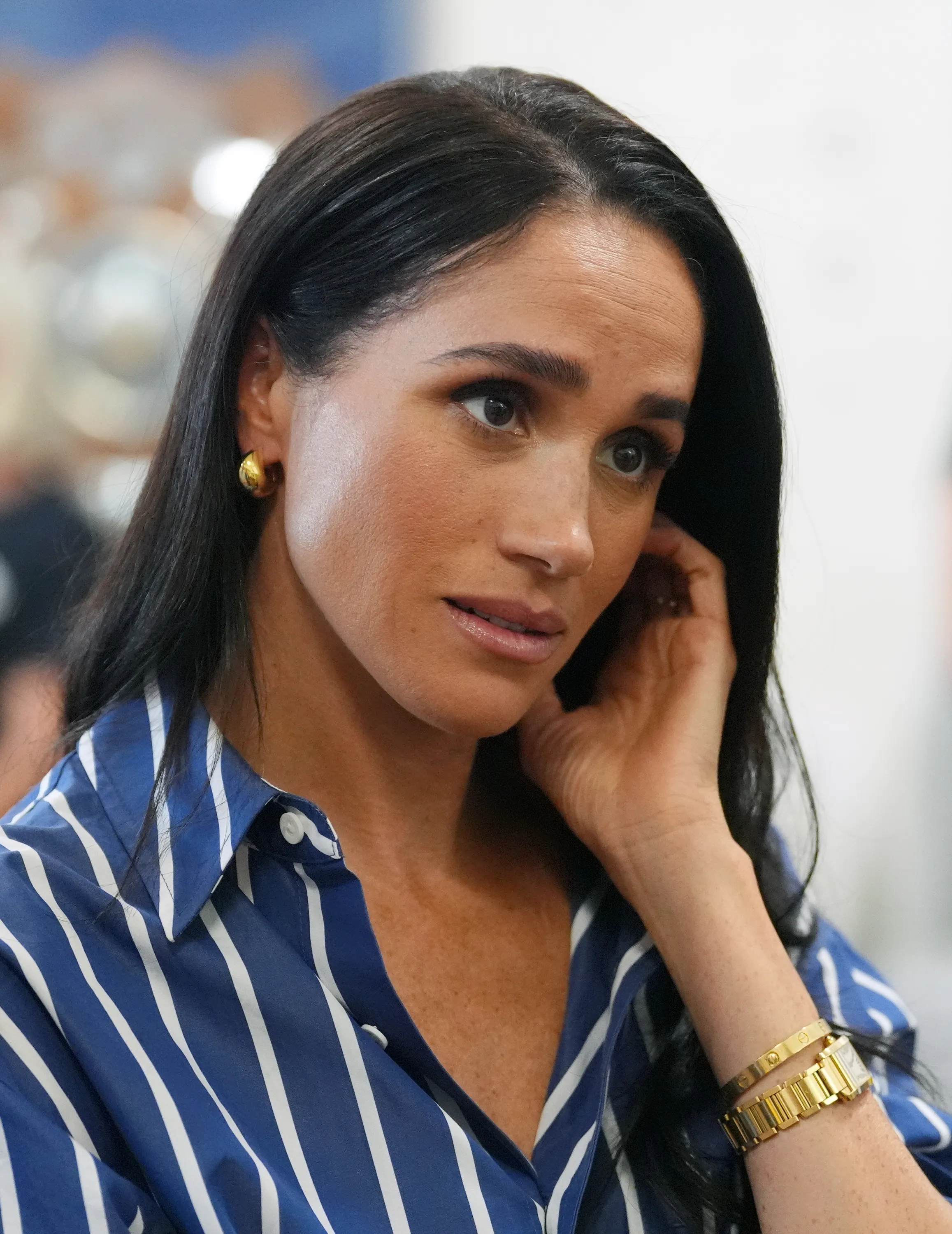 Meghan, Duchess of Sussex, wearing a blue and white striped shirt during a visit to Australia.