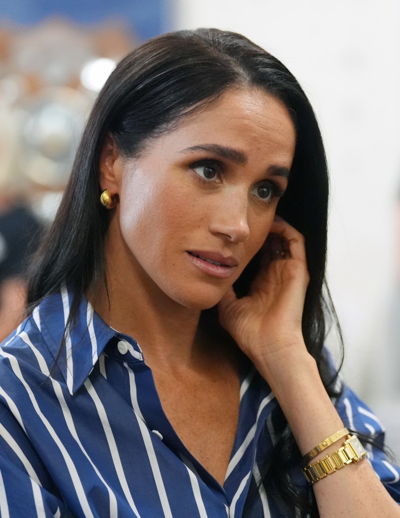 Meghan, Duchess of Sussex, wearing a blue and white striped shirt during a visit to Bondi Beach.